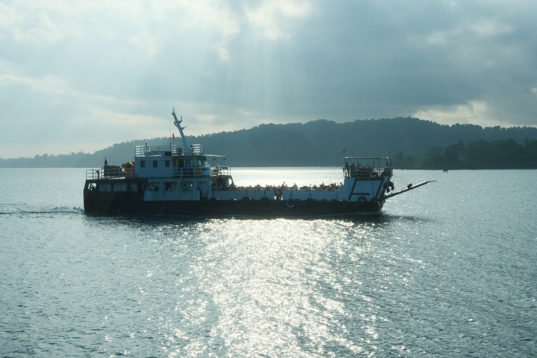 Ferry boat sailing on calm water with hills background